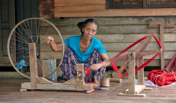 Woman spins red thread
