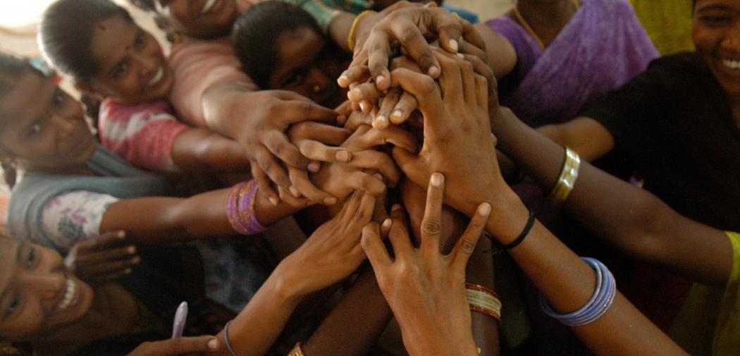 Young women hold hands during a team-building exercise in a health training centre, Pondicherry, India
