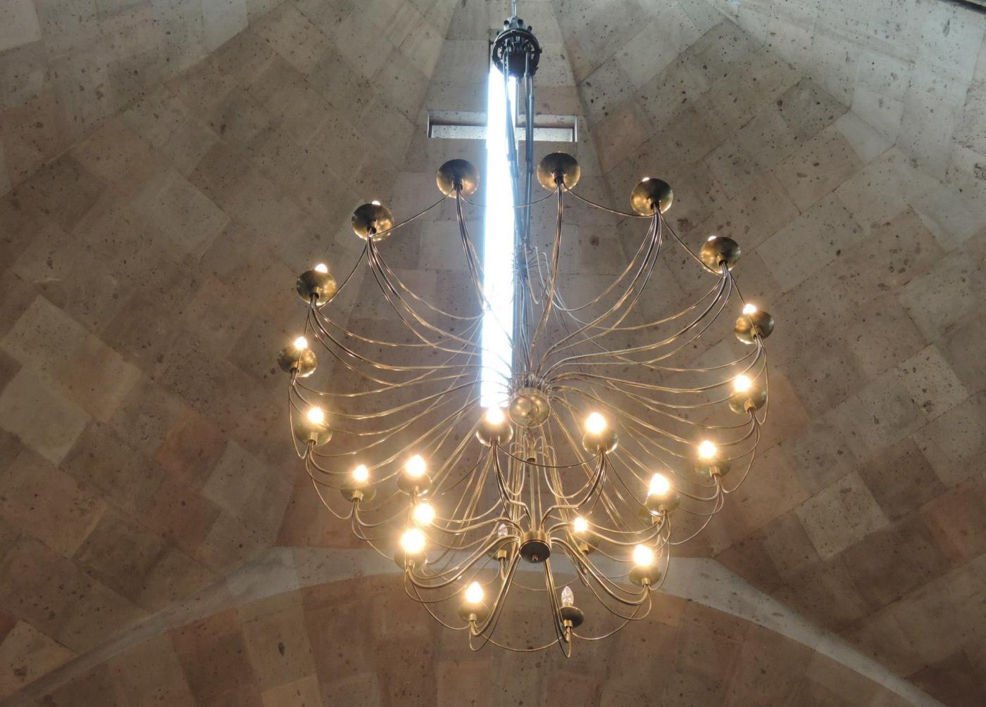 Cross and chandelier in chapel ceiling