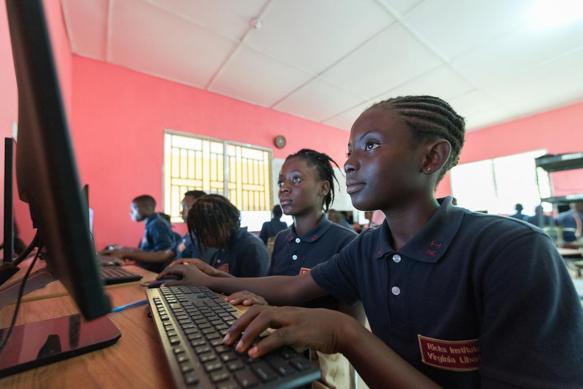 12-year-old Sodah Sackor (right) and 12-year-old Vickey V. Wion (left) study in the computer lab at Ricks Institute, Liberia, 2019..