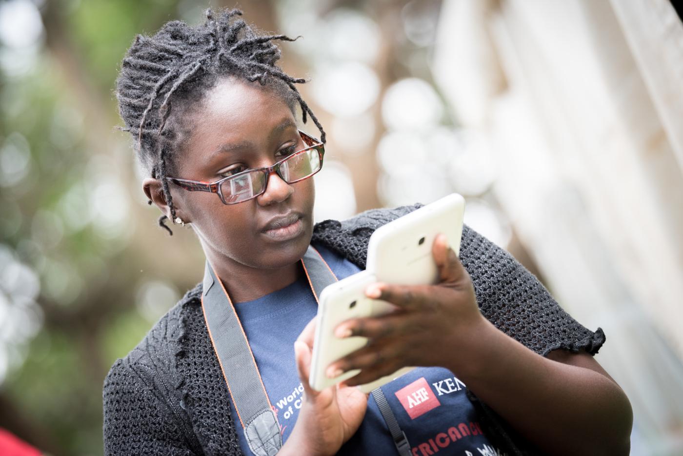 young woman looks at the screen of her phone