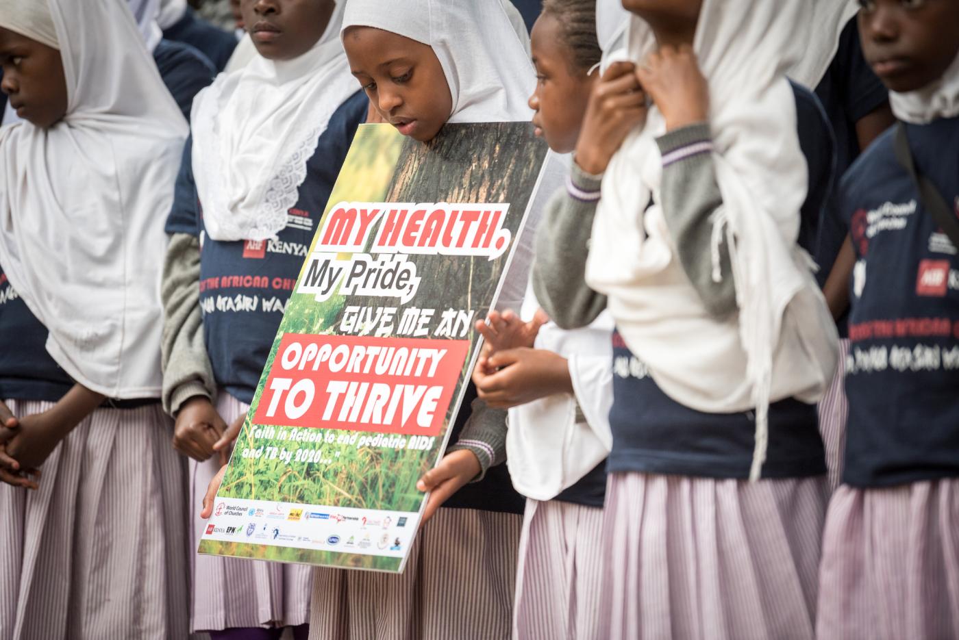 A group of African children holding a sign commemorating the Day of the African child in Kenya.