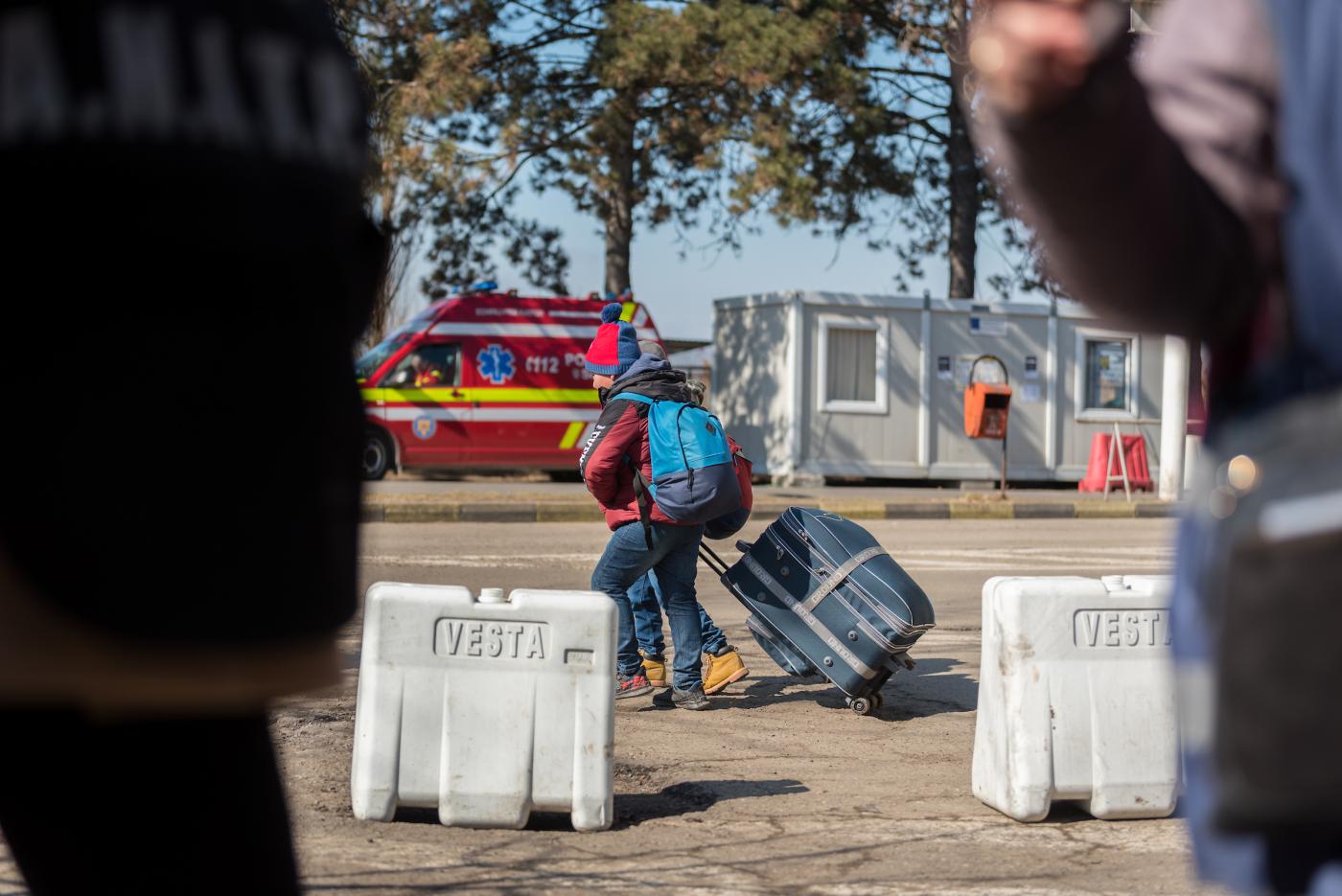 Two boys pull their suitcases as they arrive at the Vama Siret border crossing, which connects northeast Romania with Ukraine. Following the invasion of Ukraine by Russian military starting on 24 February 2022, thousands of refugees have fled across the Ukrainian border into Romania, Photo: Albin Hillert/WCC