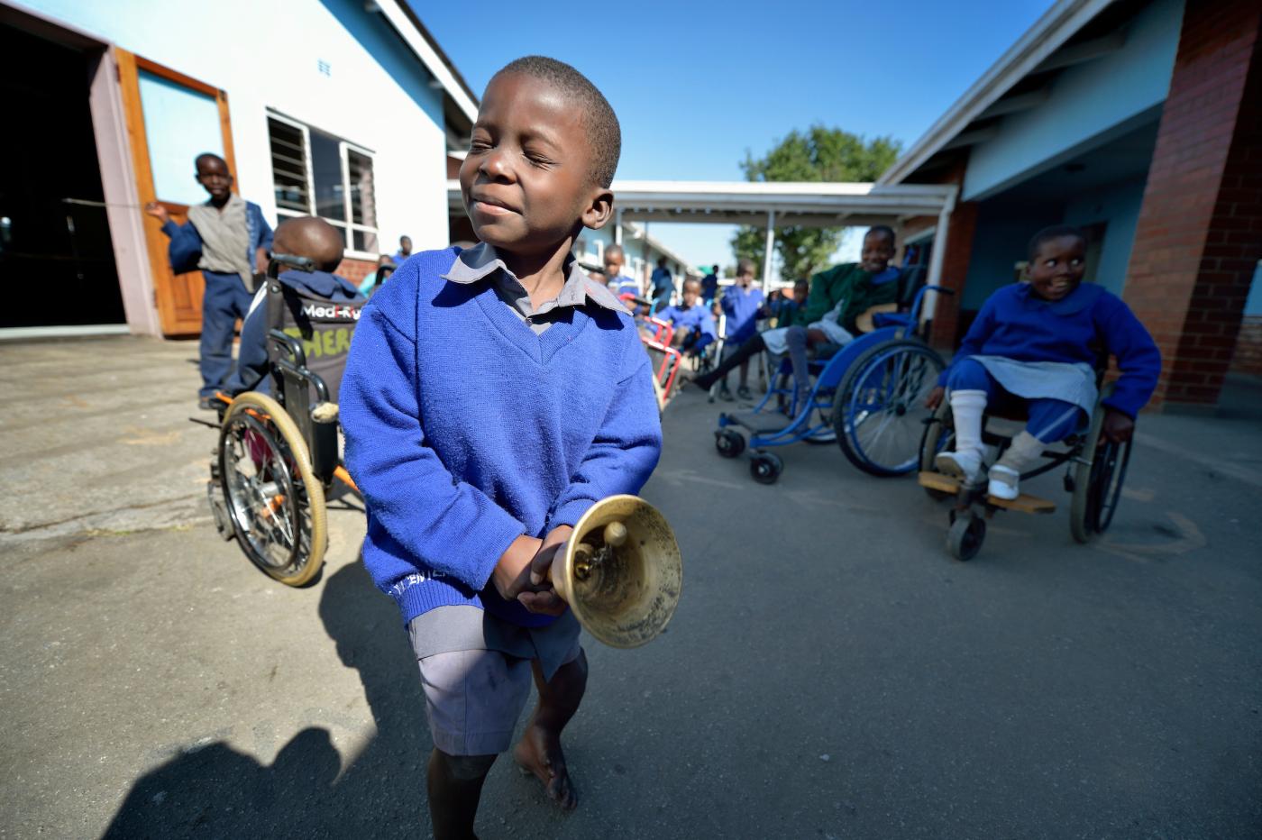 A boy rings a bell to call students to class at the Jairos Jiri School in Harare, Zimbabwe. 