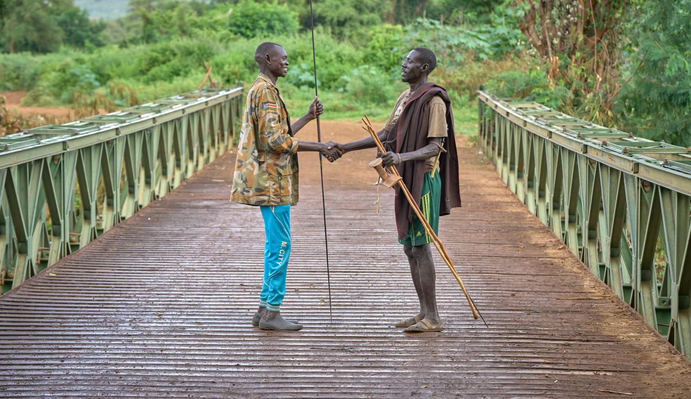 Two men shake hands on the bridge