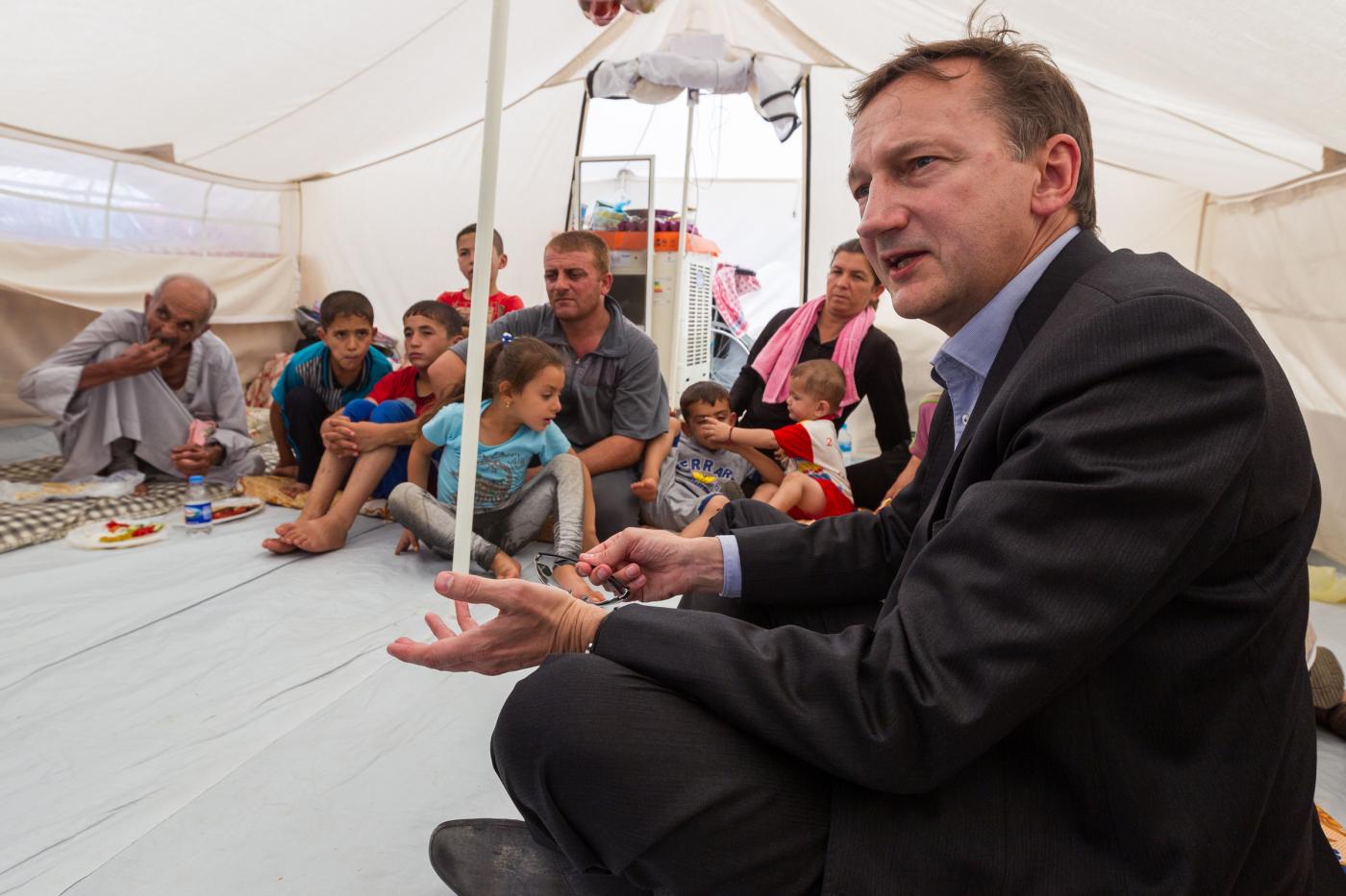 Peter Prove, CCIA director, speaks with Christian families expelled from Mosul by IS raids. These families took shelter in a tent camp established on grounds of the Chaldean Church in Erbil, Iraq. ©WCC/Gregg Brekke. Photo permission granted by parents