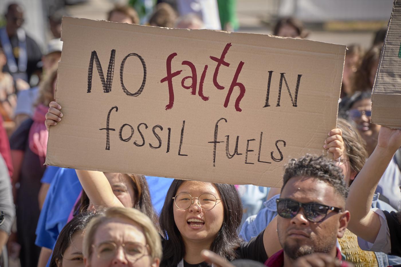 2 September 2022, Karlsruhe, Germany: A young woman holding up a sign that says "no faith in fossil fuels" 