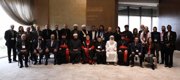 Group of religious leaders sitting for a group photo, dressed in religious garb. 