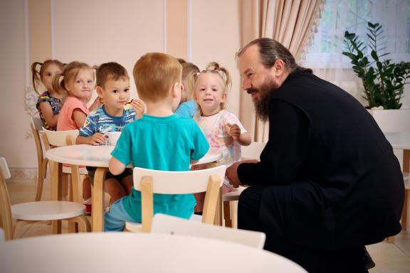 Priest speaking with children at the orphanage