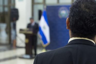 a man watches a speech in El Salvador