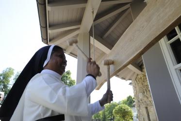 Sister Ivy Athipozhiyil ringing a wooden bell in Bossey