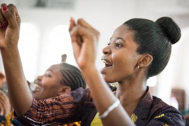 Young African woman raising hands in praise