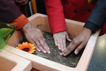Hands/seeds/soil/interreligious event