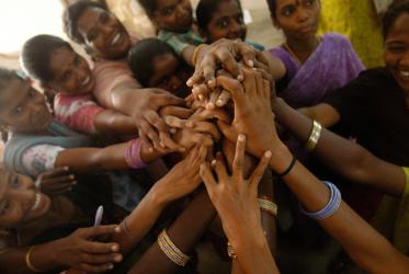 Young women hold hands during a team-building exercise in a health training centre, Pondicherry, India