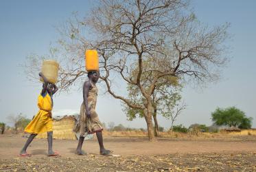 Women carry water in the cans on their heads