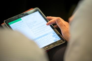 Woman types on digital tablet. 