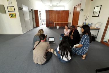 Participant of the GEM School 2022, Berlin, sitting on the floor looking at a computer