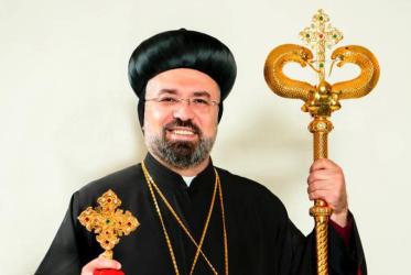 Man in Orthodox religious garb smiling.