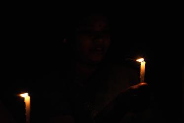 Two lighting candles in the dark