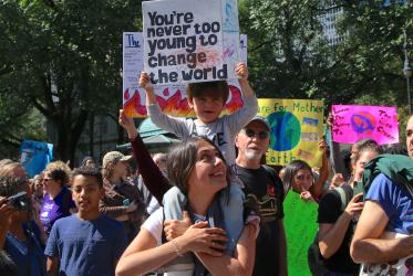 boy holds sign that reads "You are never too young to change the world", during a climate march in NYC 2019