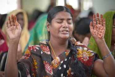 Woman prays in the church with hands raised up