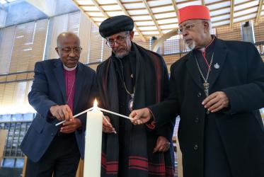 Church leaders lighting a cande
