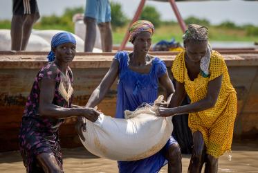three women, floods, humanitarian aid unload, Africa