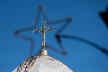 Church tower with a cross, seen through a star