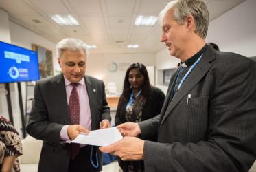 Rev. Henrik Grape, moderator of the WCC working group on climate change, hands the interfaith declaration to UNFCCC's deputy executive director Ovais Sarmad. Photo: LWF/Albin Hillert