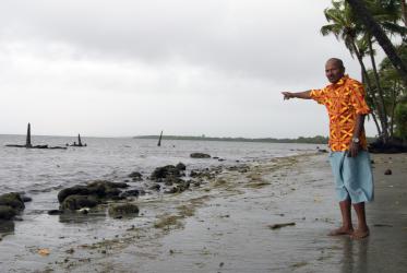 John Dunn indicates where the graveyard of his ancestors was located until 10 years ago, in Togoru. The rise of sea levels has been forcing displacement and adaptation in many parts of Fiji. Photo: Marcelo Schneider/WCC