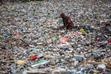 A man retrieves plastic waste in a river in Nairobi, Kenya. Photo: Sean Hawkey
