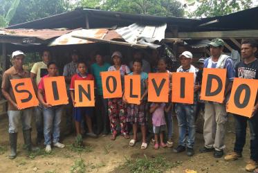 Miembros de una comunidad local en Colombia rinden homenaje a Mario Castaño. Los miembros de su familia sostienen pancartas que dicen "Sin Olvido". Photo: Jin Yang Kim/WCC