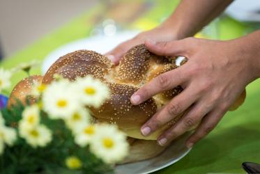  הרב תמרה שגס מברכת על שני כיכרות לחם המוגשים באופן מסורתי בארוחת שבת. כל הצילומים: אלבין הילרט/WCC
