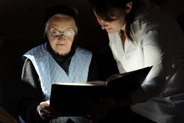 Resident and carer reading the Bible at a home for the elderly in Oradea, Romania. © United Bible Societies/Dag Smemo