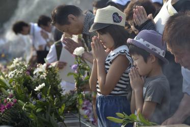 People praying on August 6, 2015, at a memorial in Hiroshima, Japan. © Paul Jeffrey