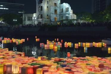 Candle lanterns drift downstream on August 6, 2015, in Hiroshima, Japan, in front of the city's atomic bomb dome. The floating lanterns, thousands of which were launched on the 70th anniversary of the atomic bombing of the city. Photo: Paul Jeffrey/WCC