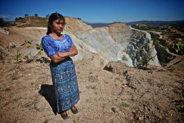 A young Sipacapa indigenous woman, stands in front of the main pit at the Marlin mine, in Guatemala. ©Sean Hawkey/WCC
