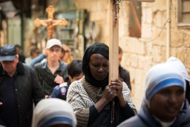 Mujer recorriendo la Vía Dolorosa con una cruz en Jerusalén, abril de 2019. Foto: Albin Hillert/CMI