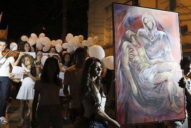 People carry a religious painting as they march in tribute to the victims of the night club fire in the city of Santa Maria, Brazil. © Reuters/Edison Vara